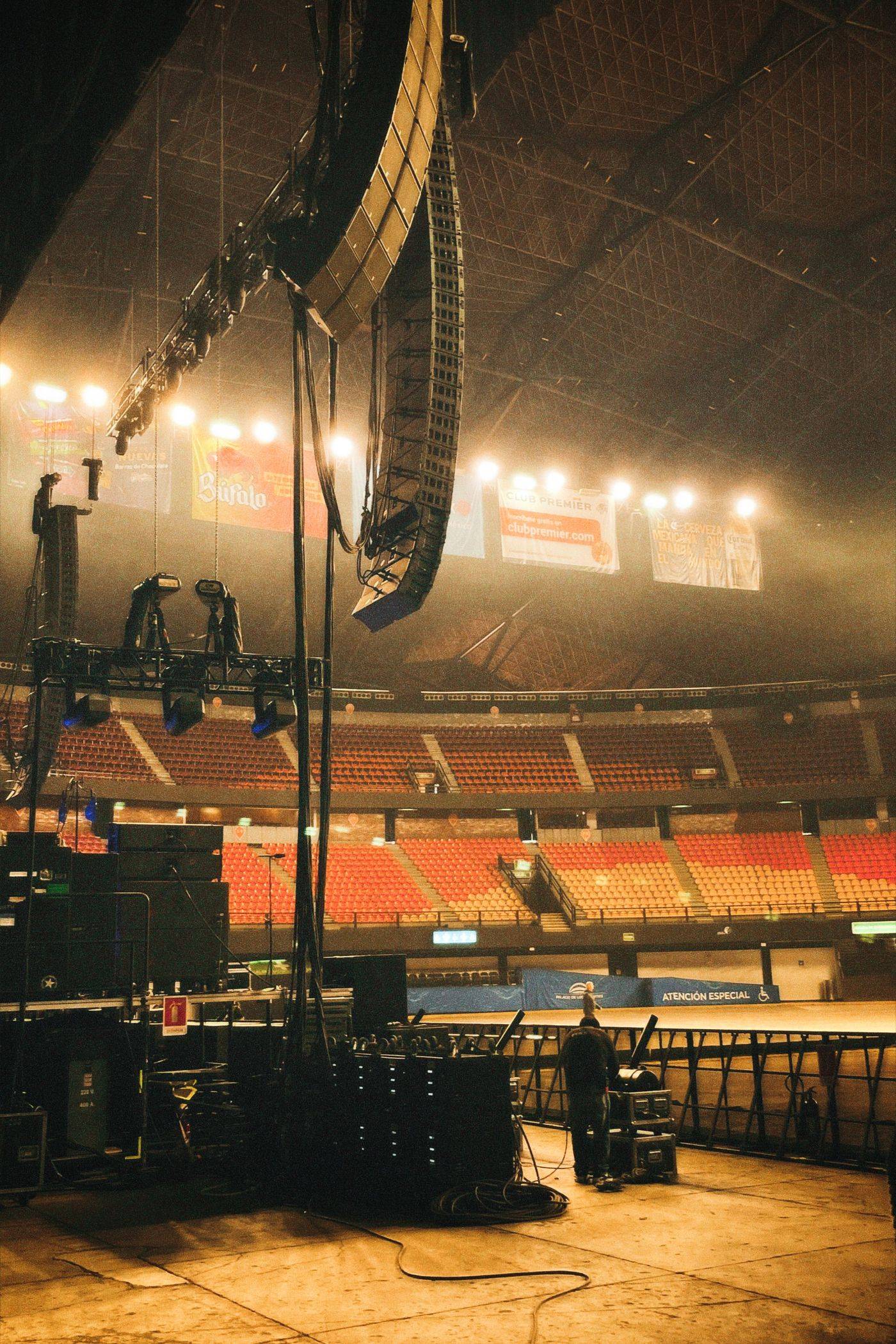 Line array-høyttalere hengende over en konsertscene